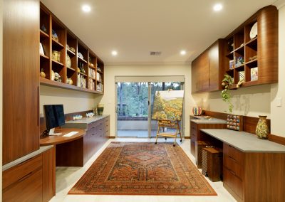 Home office with bookshelves, display cabinets, drawers, printer cupboard, file drawers, desk.