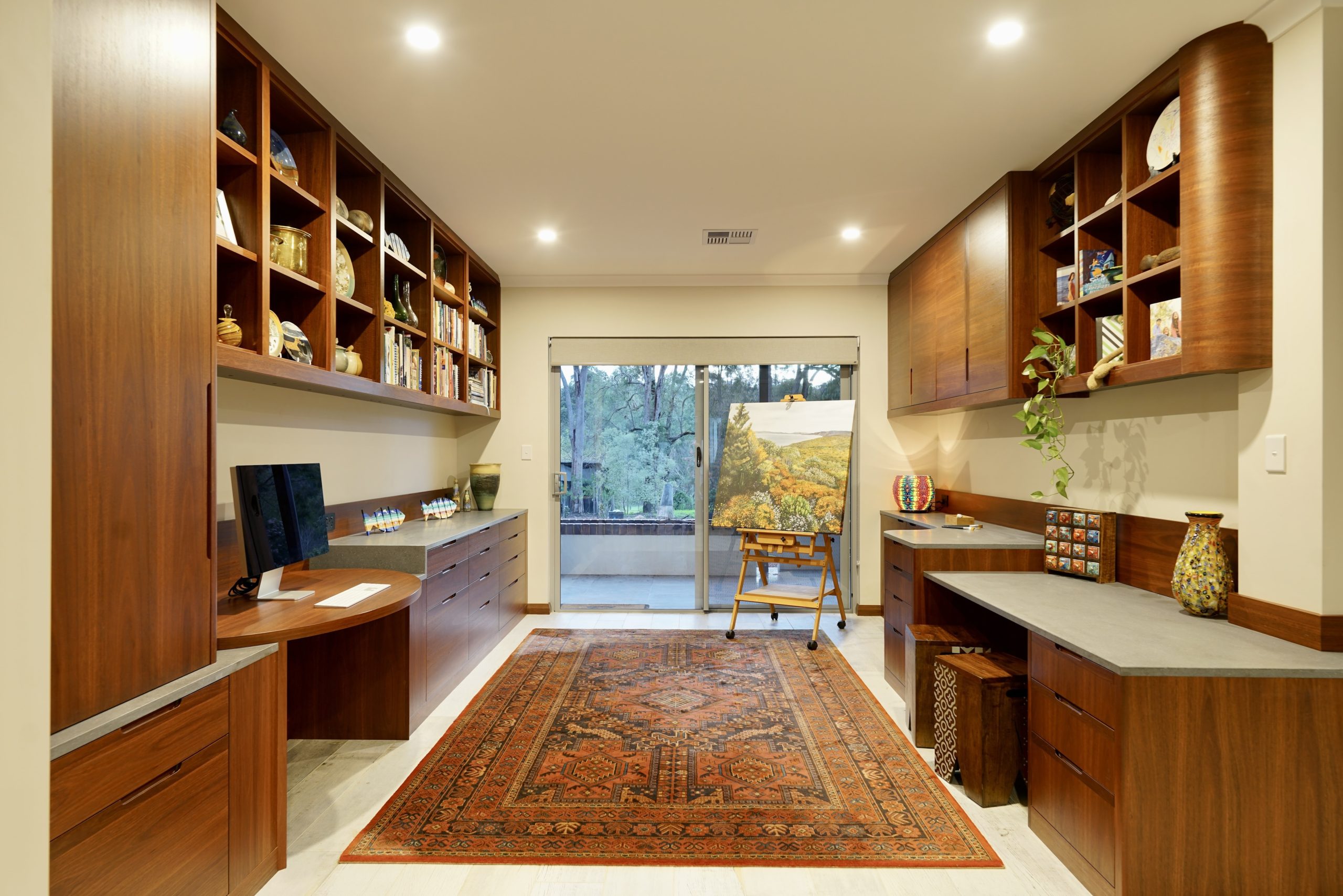 Home office with bookshelves, display cabinets, drawers, printer cupboard, file drawers, desk.